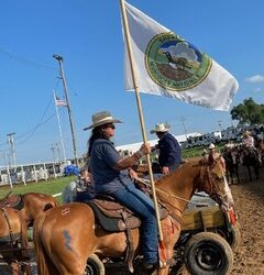 Bristow community chairwoman carries the Muscogee flag at rodeo